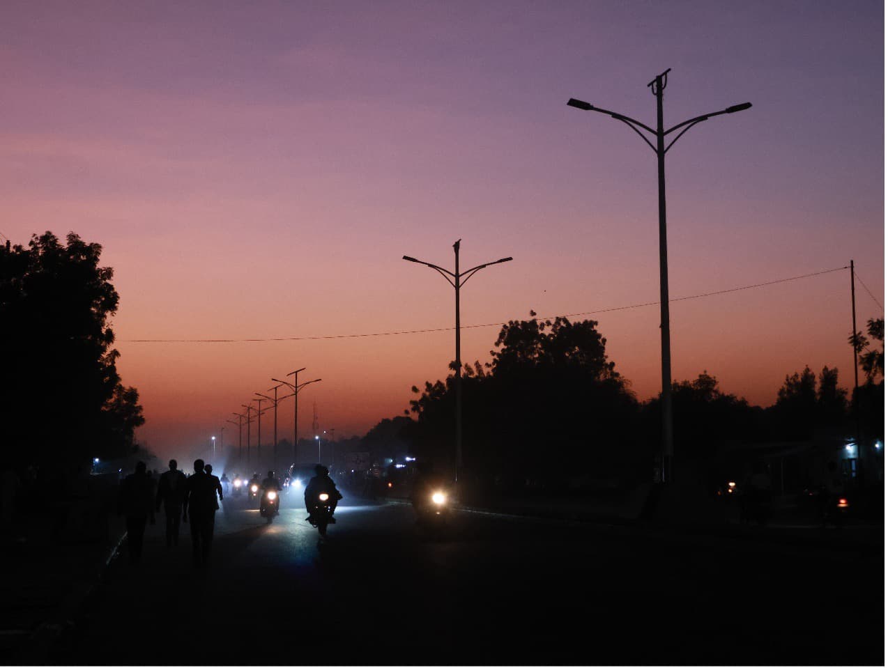 A road in N’Djamena at dusk, with the nearest stretch still unlit.